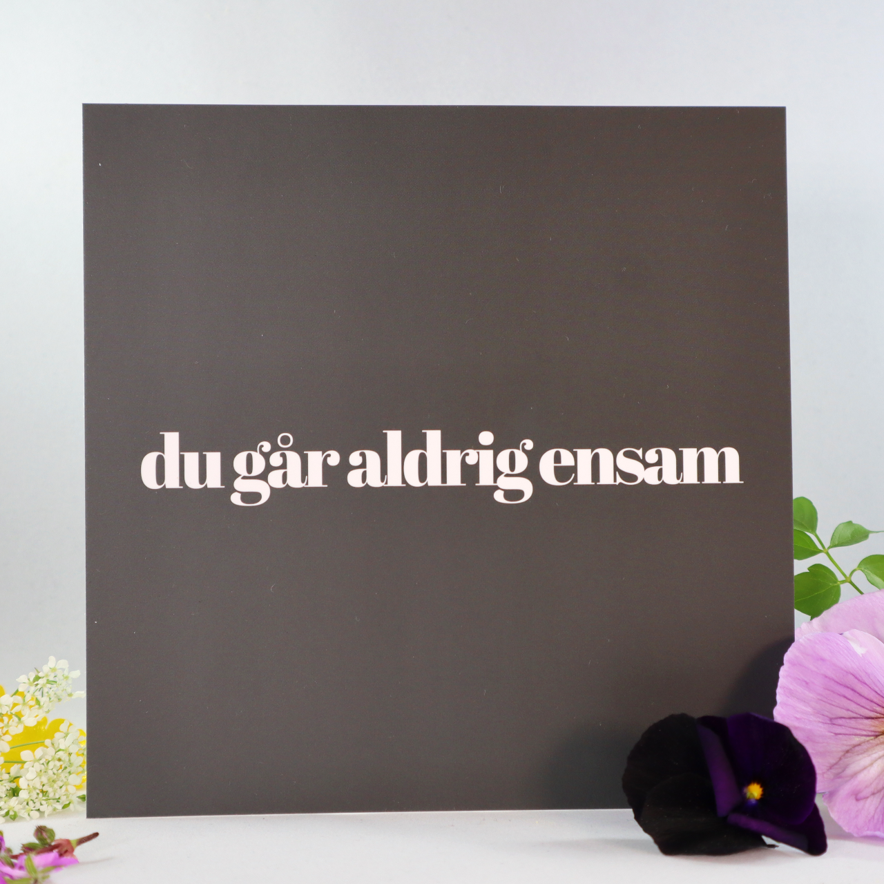 Du går aldrig ensam. Svart kort med vit text. Design by Andreas