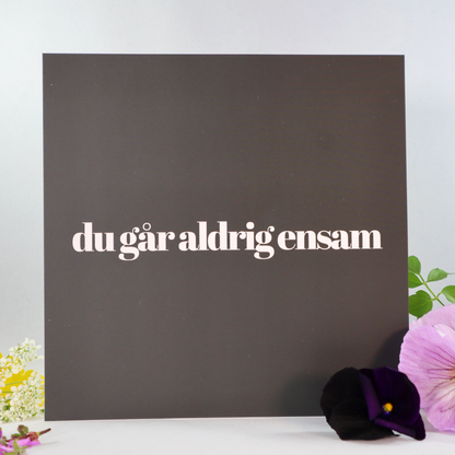 Du går aldrig ensam. Svart kort med vit text. Design by Andreas