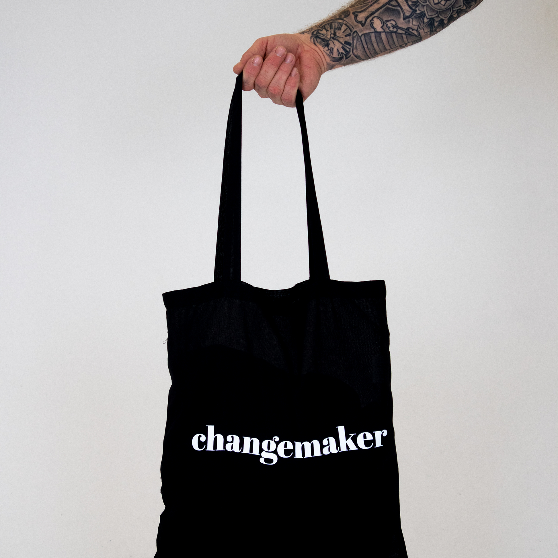 Tygkasse Changemaker, hålls upp mot vit bakgrund