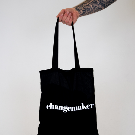 Tygkasse Changemaker, hålls upp mot vit bakgrund