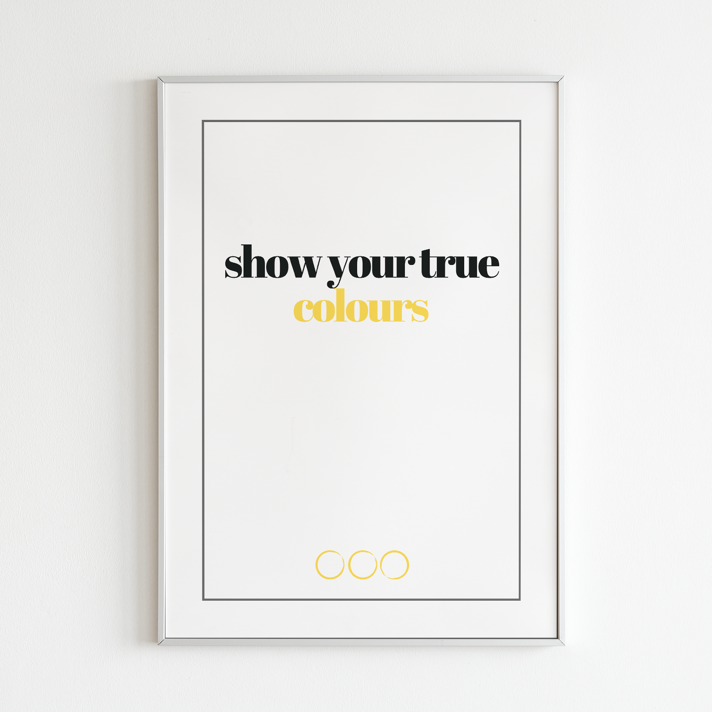 Poster True colours, gold. Texten "colours" i guldfoliering. inramad mot vit vägg