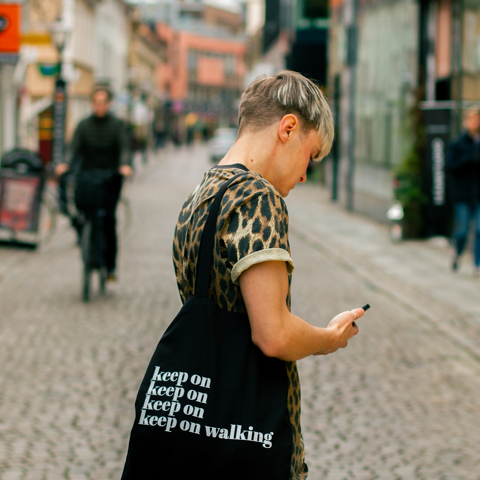 Tygkasse Keep on, modell med kasse på axeln, i stadsmiljö