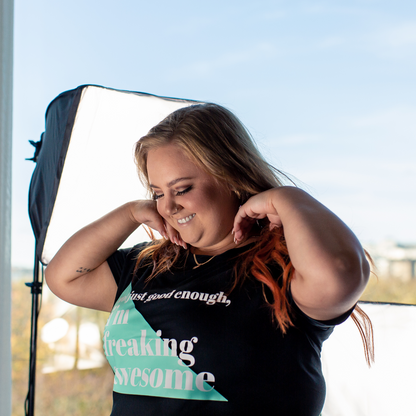 T-shirt Freaking Awesome, model som ordnar till håret ståendes framför en fotolampa