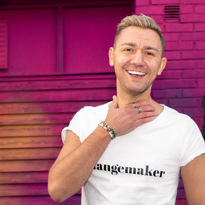 T-shirt Changemaker. Manlig modell i vit t-shirt framför rosa  vägg