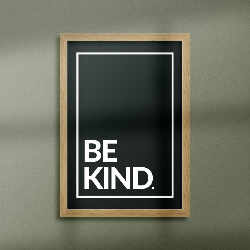 Poster Be kind, vita bokstäver mot svart bakgrund Inramad mot grön vägg