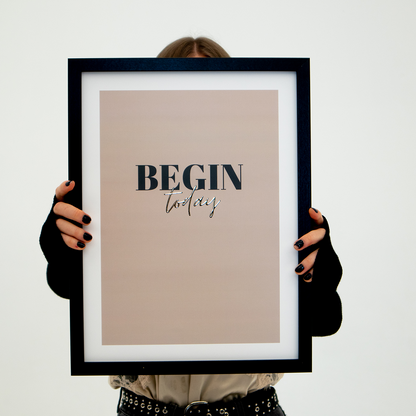 Poster begin today, inramad. En person håller upp tavlan så att ansiktet skyms.