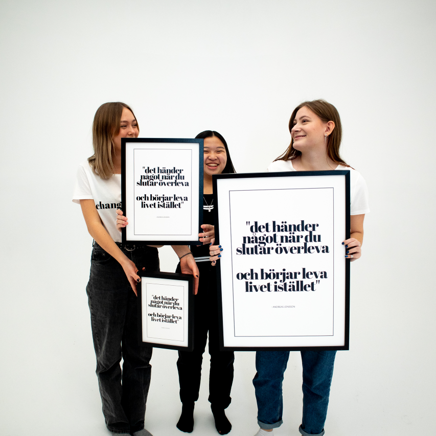 Poster Det händer något, inramad, alla tre storlekar hålls upp av tre unga kvinnor som ler