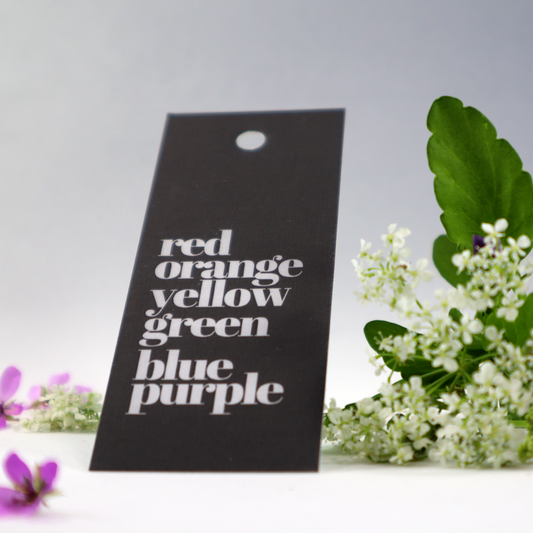 Hang Tag med regnbågens färger utskrivna i engelsk text.