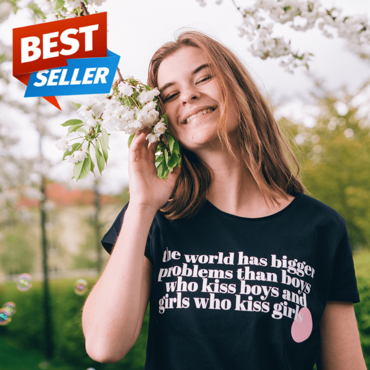 T-shirt The World has Bigger Problems, modell som håller en vit blomma mot sin kind, träd och såpbubblor i bakgrunden 