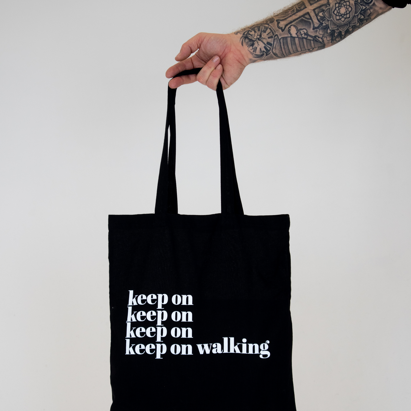 Tygkasse Keep on, hålls upp mot vit bakgrund