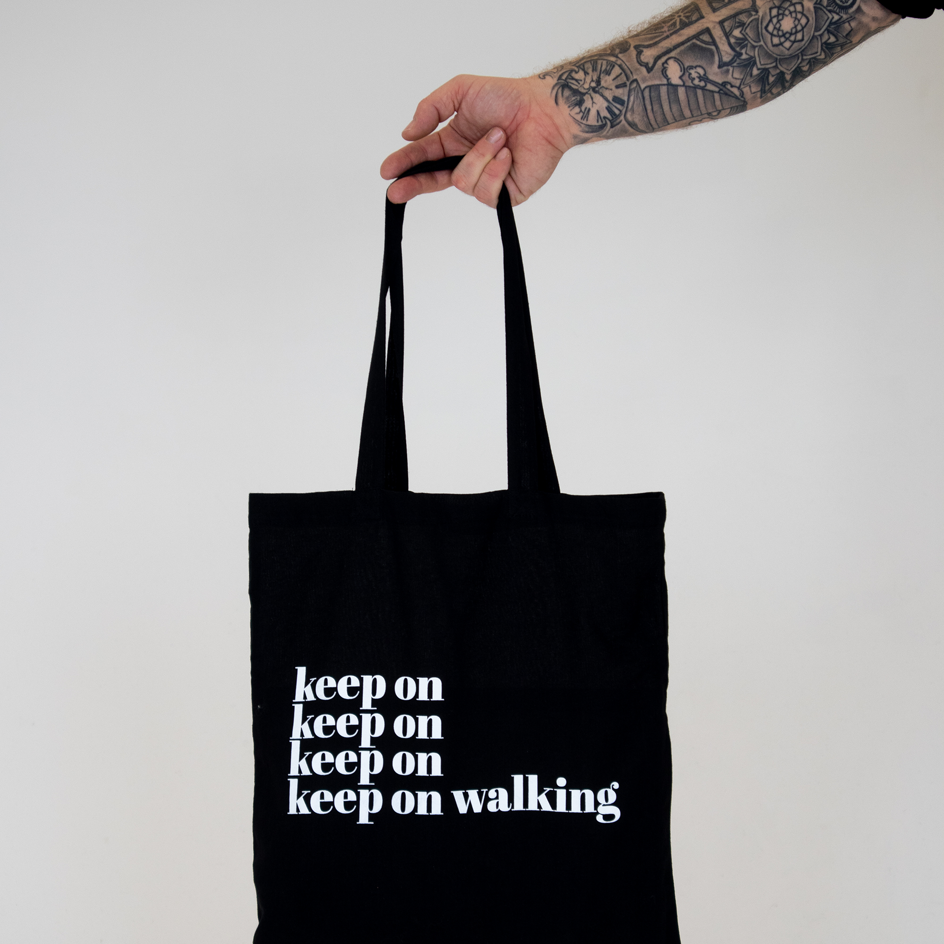Tygkasse Keep on, hålls upp mot vit bakgrund