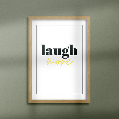 Poster Laugh More gold texkten "more" i guldfoliering, inramad mot grön vägg