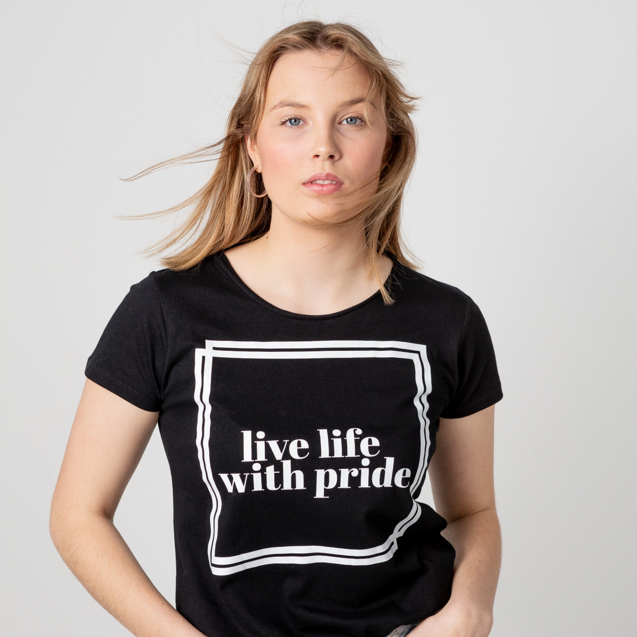 T-shirt Live Life, modell där håret blåser lätt fram ör ansiktet, vit bakgrund