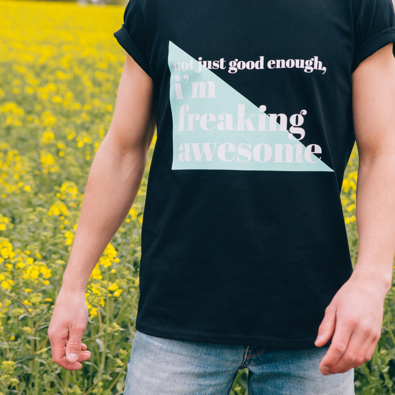 T-shirt Freaking Awesome, model där endast t-shirt och armar syns, framför ett rapsfält.