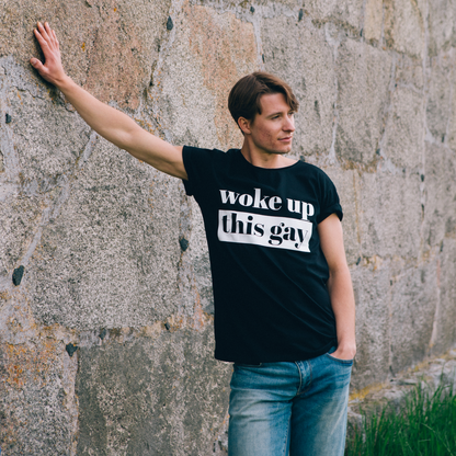 T-shirt Woke up this Gay,  modell lutar sig mot gammal stenvägg